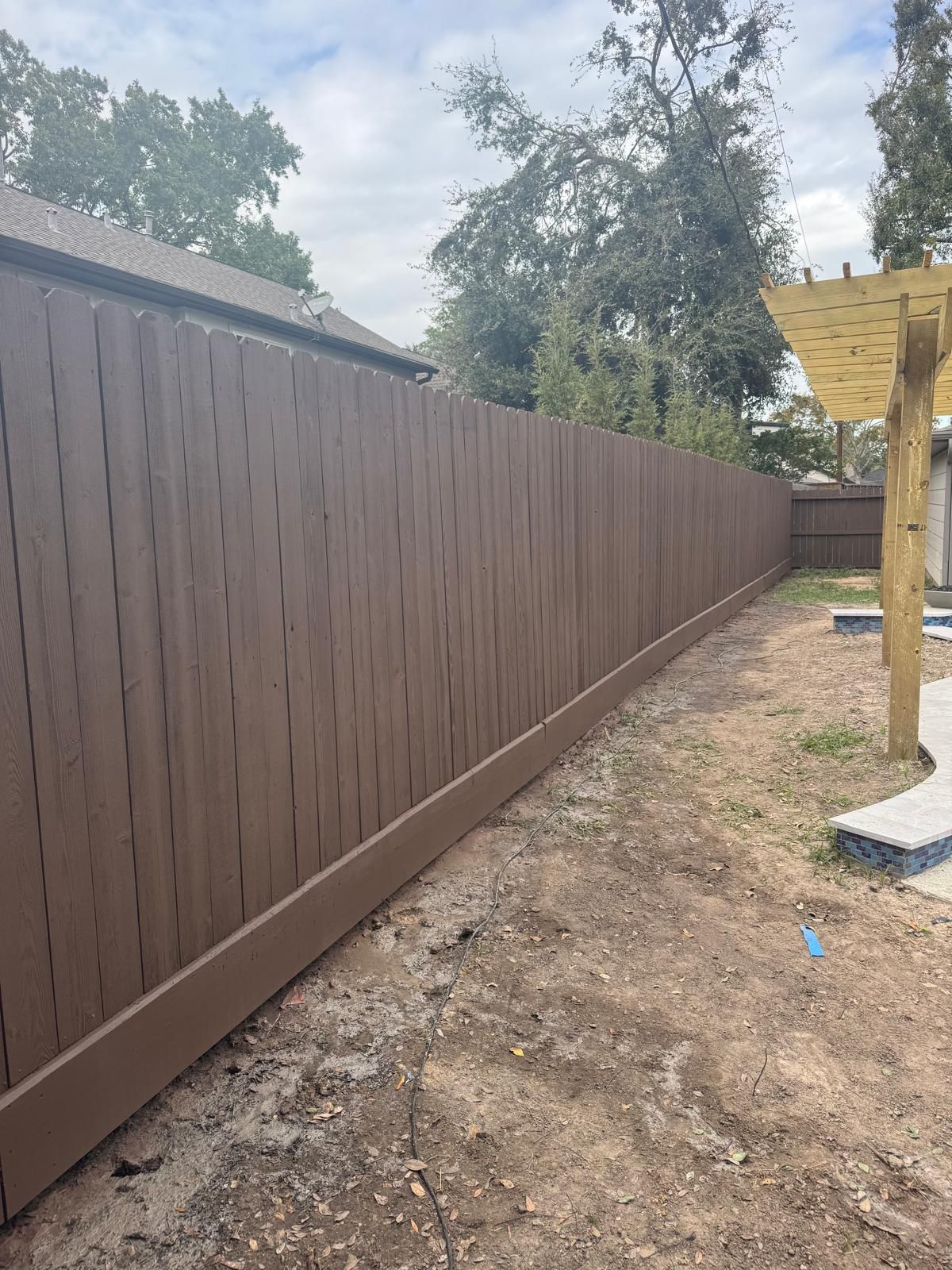 Dark brown painted fence after painting